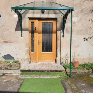 marquise métallique avec verre posée au-dessus d'une entrée à clairegoutte